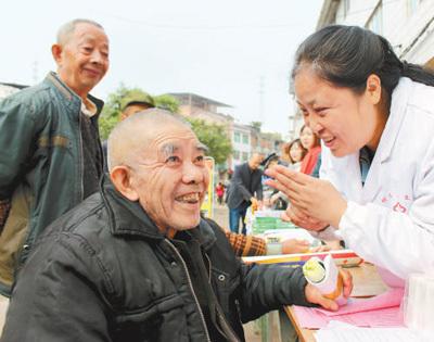 市东兴区柳桥镇一名农村留守老人向医疗服务队的志愿者进行健康咨询